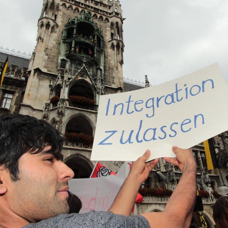 Demonstrant mit Plakat und Aufschrift "Integration zulassen"

