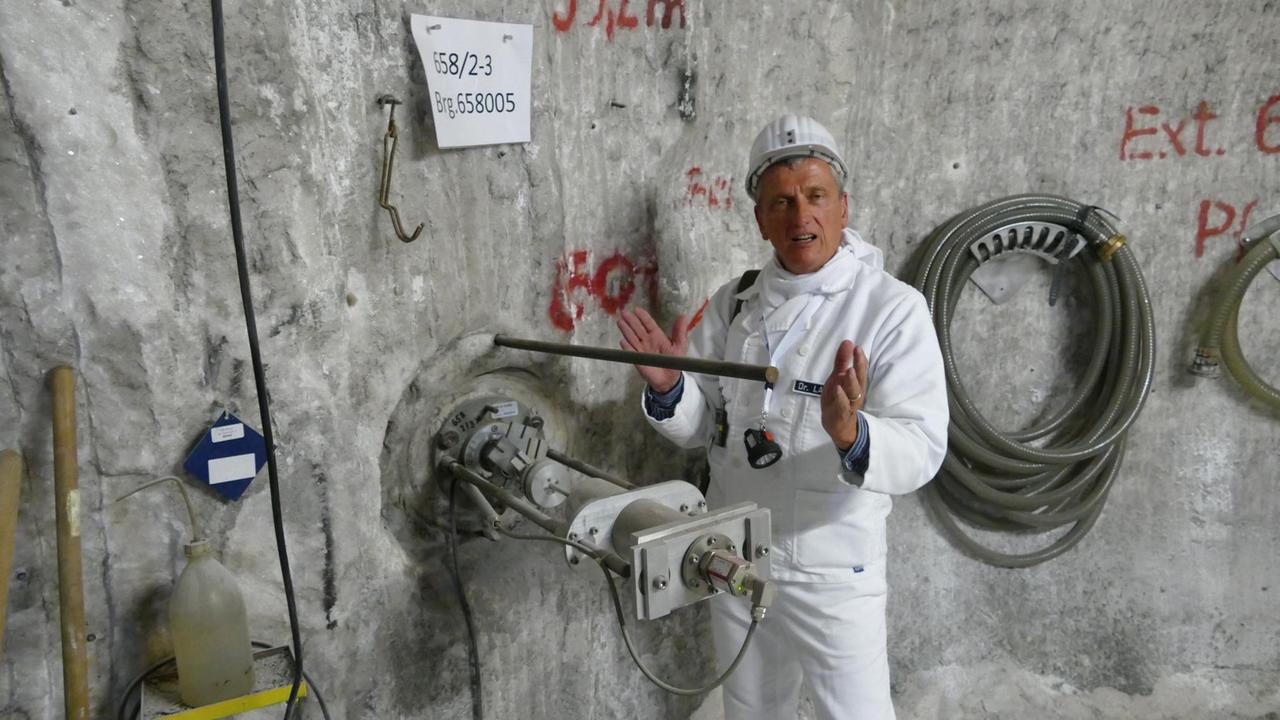 BGE-Geschäftsführer Thomas Lautsch steht an einer Wand der Asse, in der ein Fissurometer zur Gebirgsbeobachtung steckt.