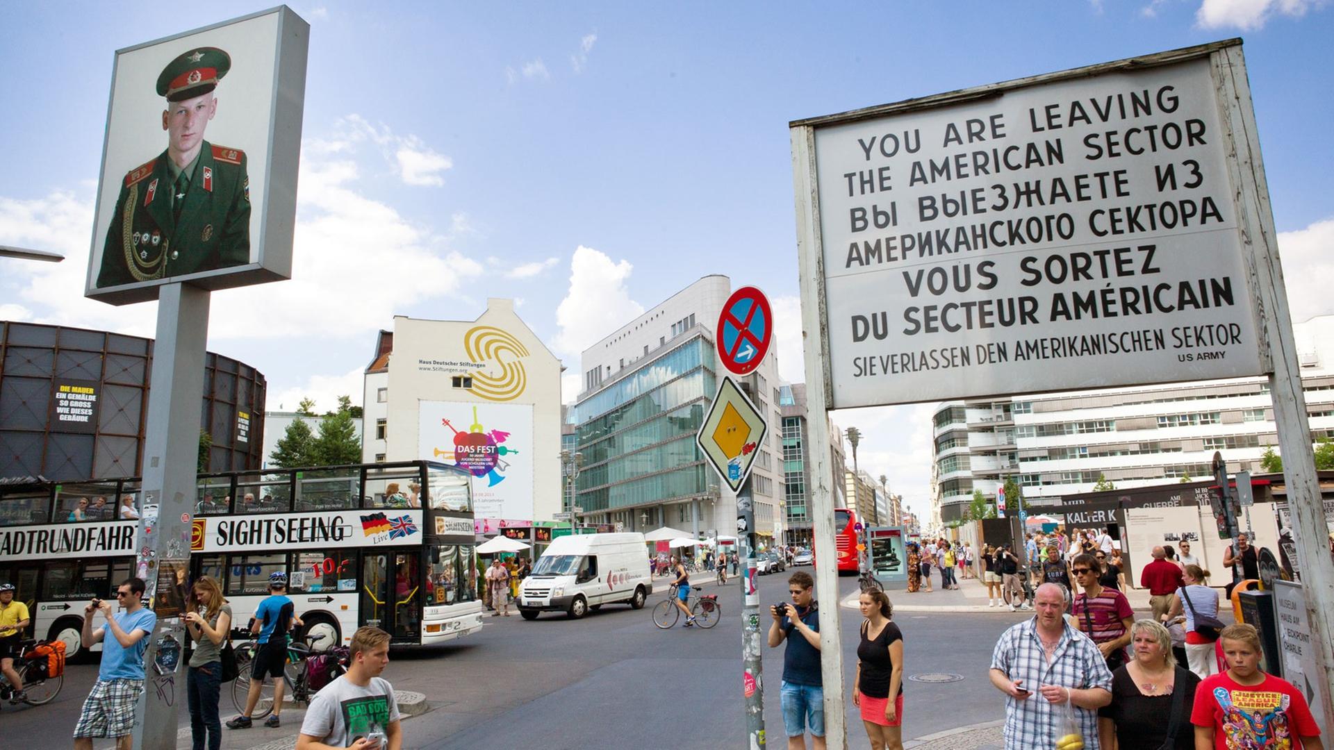 Touristen schauen sich am 18.07.2013 den ehemaligen Grenzübergang "Checkpoint Charlie" in Berlin (Berlin) an. Touristen schauen sich am 18.07.2013 den ehemaligen Grenzübergang "Checkpoint Charlie" in Berlin (Berlin) an.