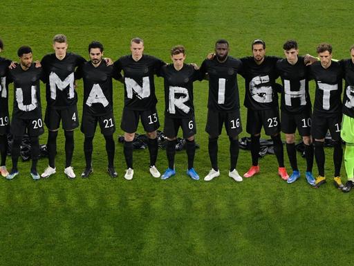 Deutsche Fußball-Nationalelf mit Buchstaben auf Trikots, die zusammen "Human Rights" ergeben