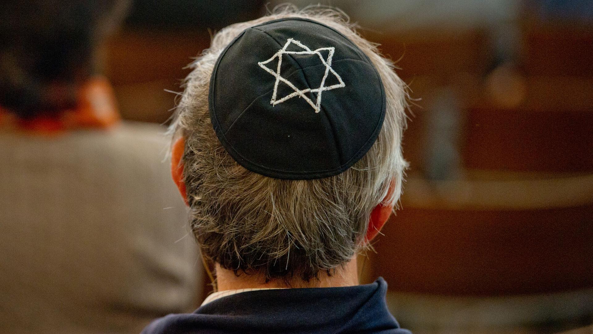 Ein Mann mit einer Kippa sitzt anlässlich einer Gedenkveranstaltung zum 75. Jahrestag der Reichspogromnacht in der Synagoge in Dresden. Ein Mann mit einer Kippa sitzt anlässlich einer Gedenkveranstaltung zum 75. Jahrestag der Reichspogromnacht in der Synagoge in Dresden.