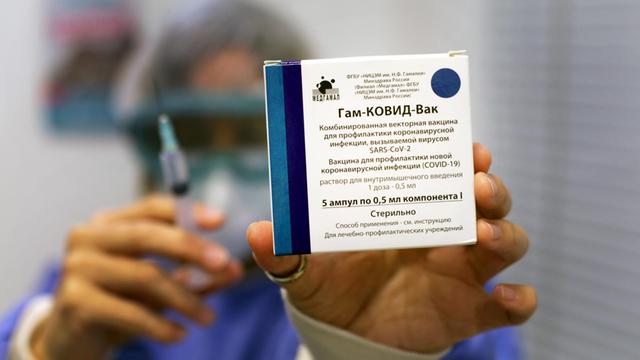 Eine Krankenschwester in Argentinien hält eine Spritze und die Verpackung des russischen Impfstoffs Sputnik V in die Kamera