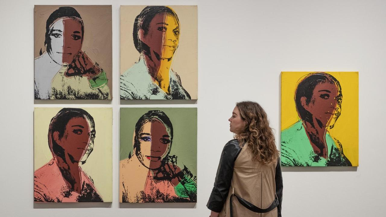 Eine Mitarbeiterin der Galerie Tate Modern betrachtet das Bild "Alphanso Panell" aus der Serie "Ladies and Gentlemen" (1975) von Andy Warhol. Eine Mitarbeiterin der Galerie Tate Modern betrachtet das Bild "Alphanso Panell" aus der Serie "Ladies and Gentlemen" (1975) von Andy Warhol.
