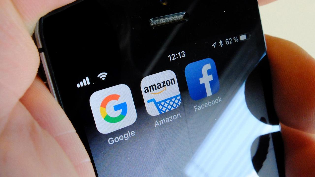 Die Logos der US-Internetkonzerne Google (l-r), Amazon und Facebook sind auf dem Display eines iPhone zu sehen. Die Logos der US-Internetkonzerne Google (l-r), Amazon und Facebook sind auf dem Display eines iPhone zu sehen.