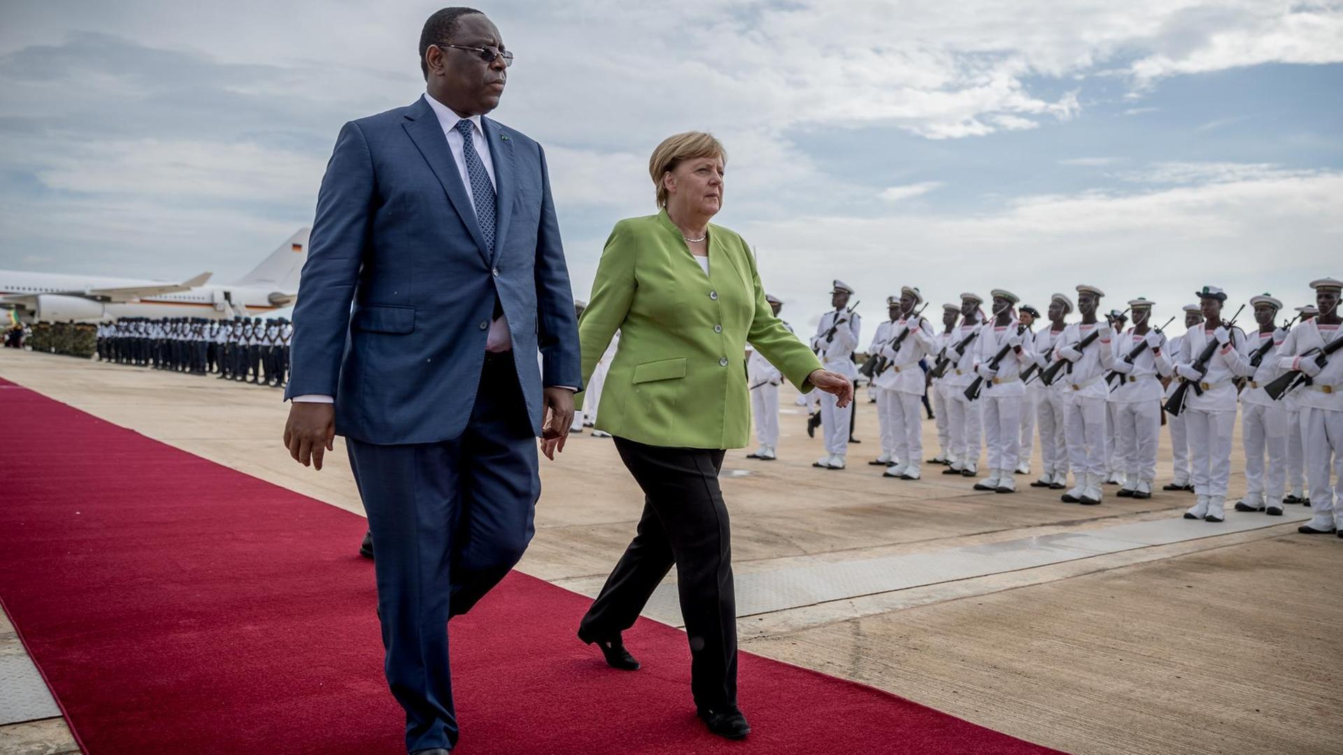 Bundeskanzlerin Angela Merkel (CDU) wird von Macky Sall, dem Präsidenten der Republik Senegal, am Flughafen begrüßt. Bundeskanzlerin Angela Merkel (CDU) wird von Macky Sall, dem Präsidenten der Republik Senegal, am Flughafen begrüßt.