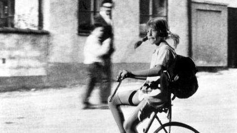 Inger Nilsson als Pippi Langstrumpf auf einem teils unsichtbaren Fahrrad. Schwarz-weiß-Aufnahme