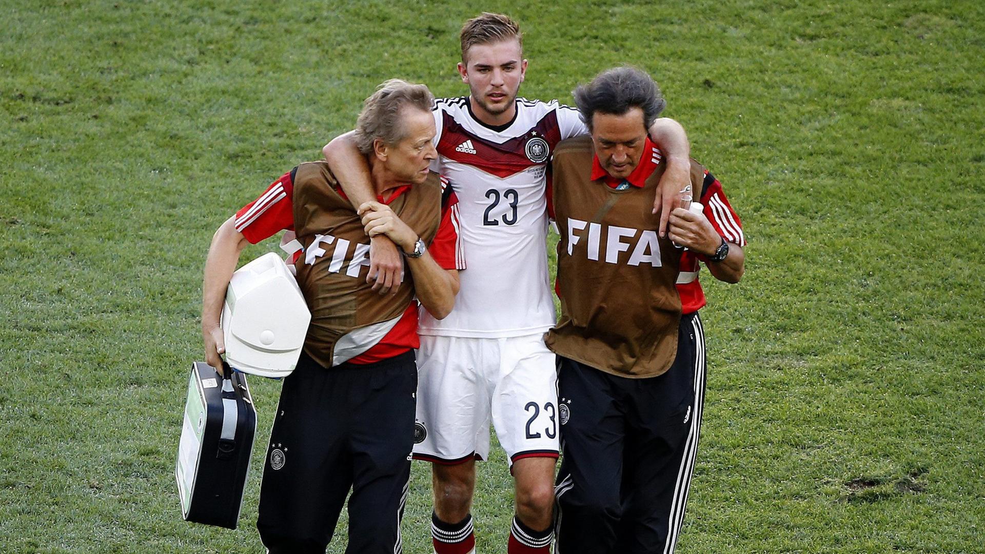 Der deutsche Fußball-Nationalspieler wird während des WM-Finales 2014 gegen Argentinien vom Platz geführt, nachdem er mit einem Gegenspieler zusammengestoßen war. Der deutsche Fußball-Nationalspieler wird während des WM-Finales 2014 gegen Argentinien vom Platz geführt, nachdem er mit einem Gegenspieler zusammengestoßen war.