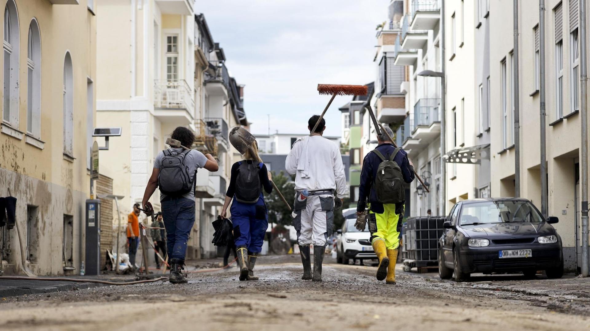 Im Bild gehen freiwillige Helfer in der Ortschaft Bad Neuenahr durch eine von dem Jahrhunderthochwasser zerstörte Straße. Im Bild gehen freiwillige Helfer in der Ortschaft Bad Neuenahr durch eine von dem Jahrhunderthochwasser zerstörte Straße.