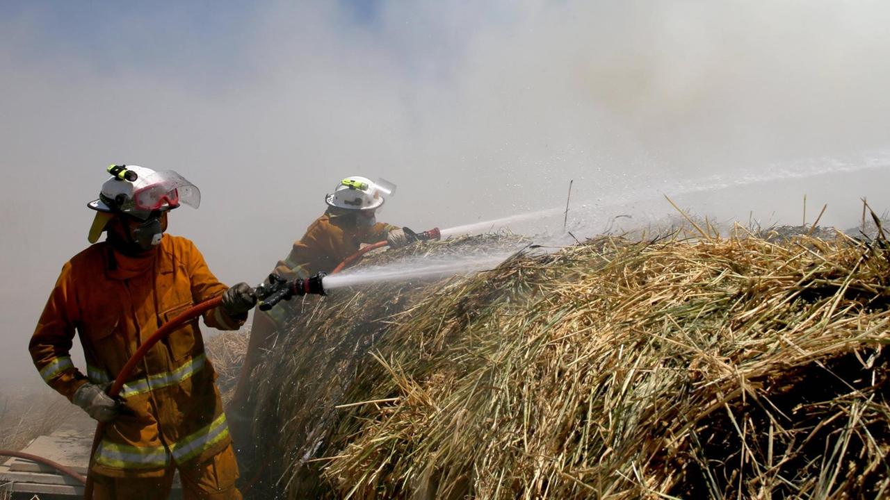 Feuerwehrleute versuchen, eine Farm zu verteidigen Feuerwehrleute versuchen, eine Farm zu verteidigen