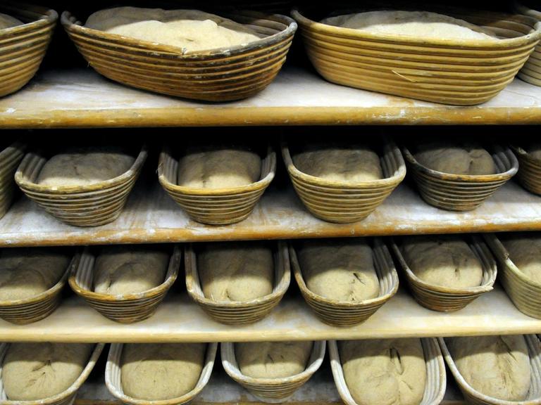 Brotrohlinge liegen in Holzkörben einer Bäckerei.