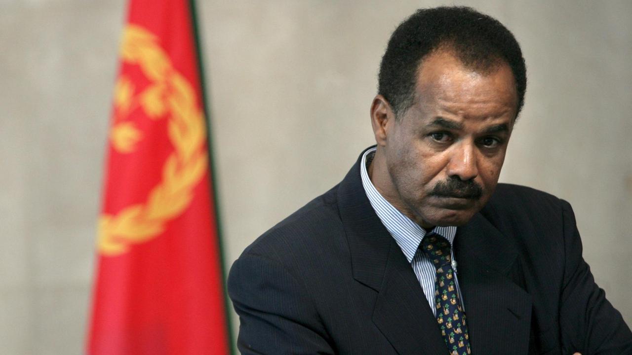 Eritreas Präsident Isaias Afewerki 2007 in Brüssel, vor einer Fahne stehend, die Arme verschränkt.