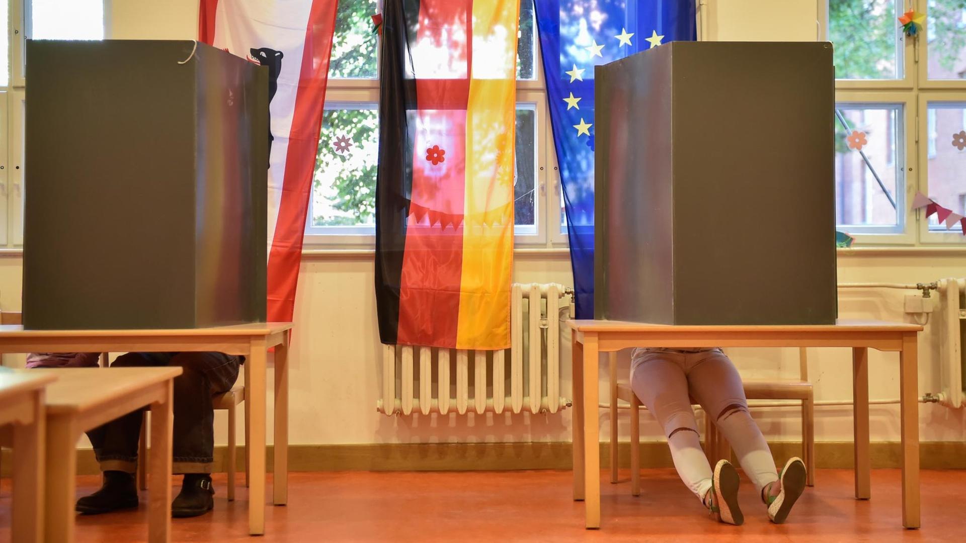 Wähler sitzen am 18.09.2016 bei der Abgeordnetenhauswahl in Berlin in einem Wahllokal in der Wahlkabine. Wähler sitzen am 18.09.2016 bei der Abgeordnetenhauswahl in Berlin in einem Wahllokal in der Wahlkabine.
