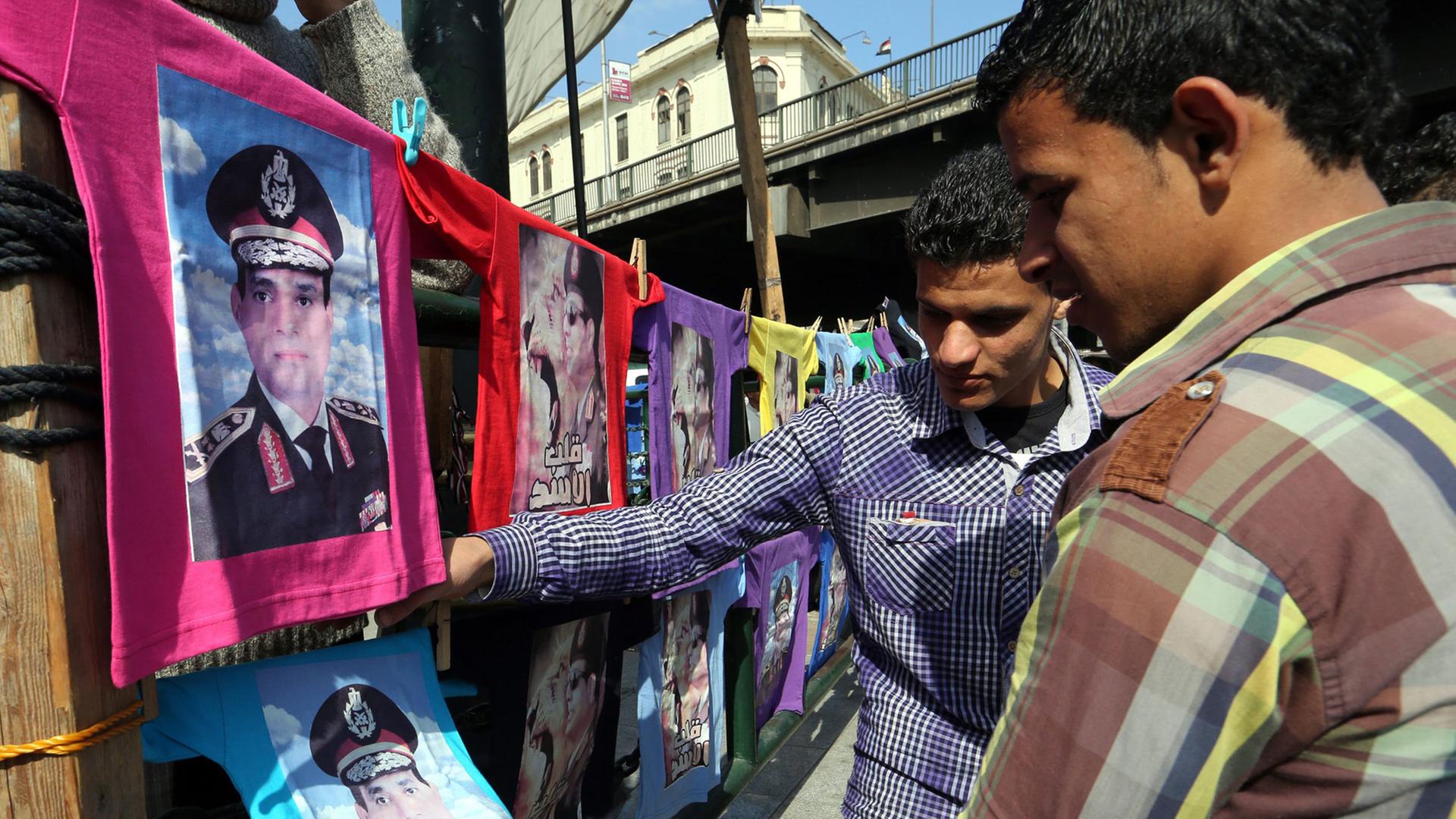 Zwei ägyptische Männer betrachten T-Shirts mit dem Bild von Abdel Fattah al Sisi. Zwei ägyptische Männer betrachten T-Shirts mit dem Bild von Abdel Fattah al Sisi.