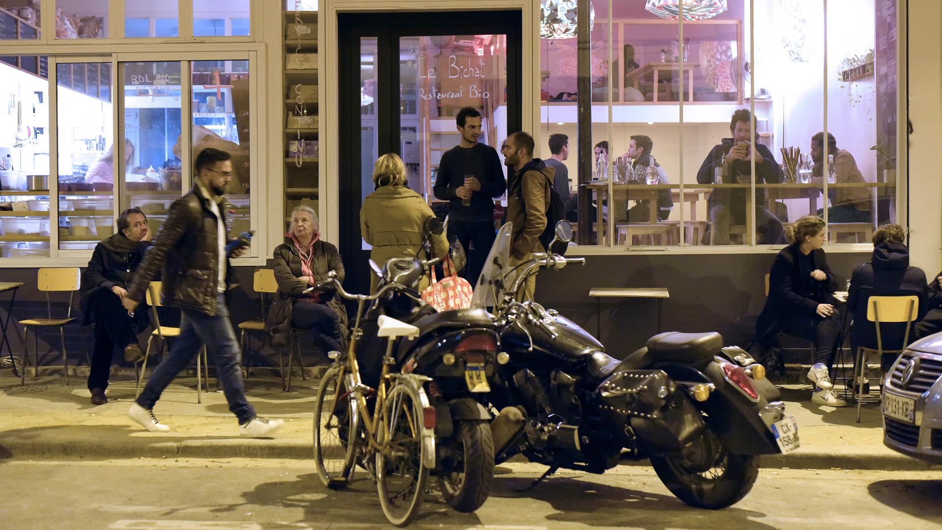 Nach den Terroranschlägen kommen Menschen in einem Restaurant in Paris zusammen.