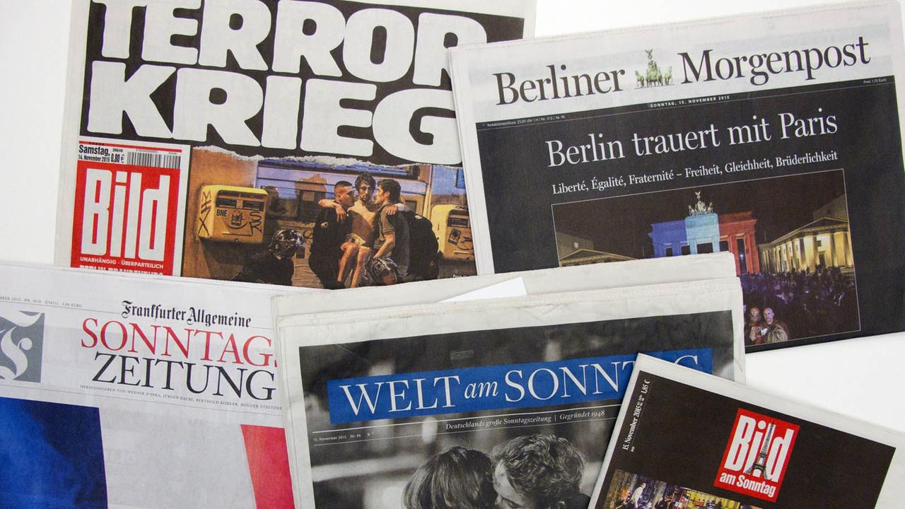 Zeitungen mit Titelseiten zu den Anschlägen von Paris.