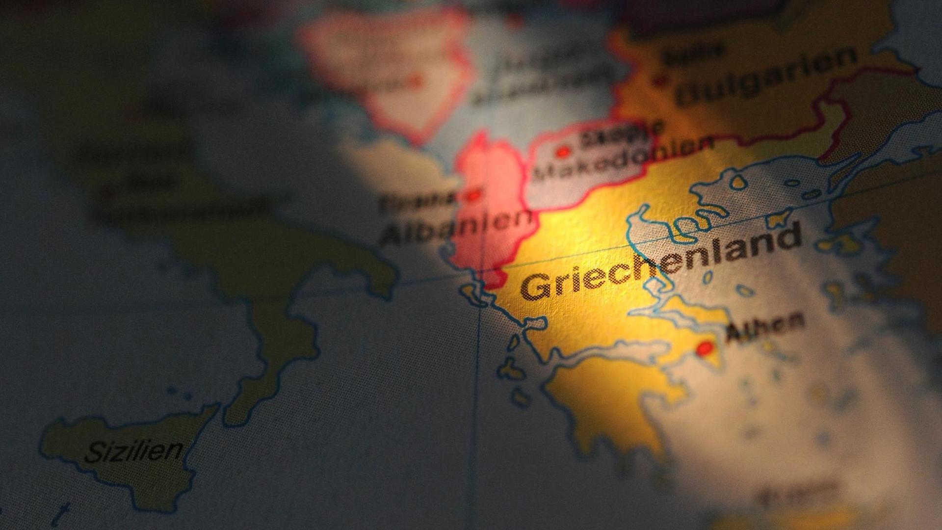 Griechenland wird auf einer Europa-Karte von der Seite angestrahlt. Griechenland wird auf einer Europa-Karte von der Seite angestrahlt.