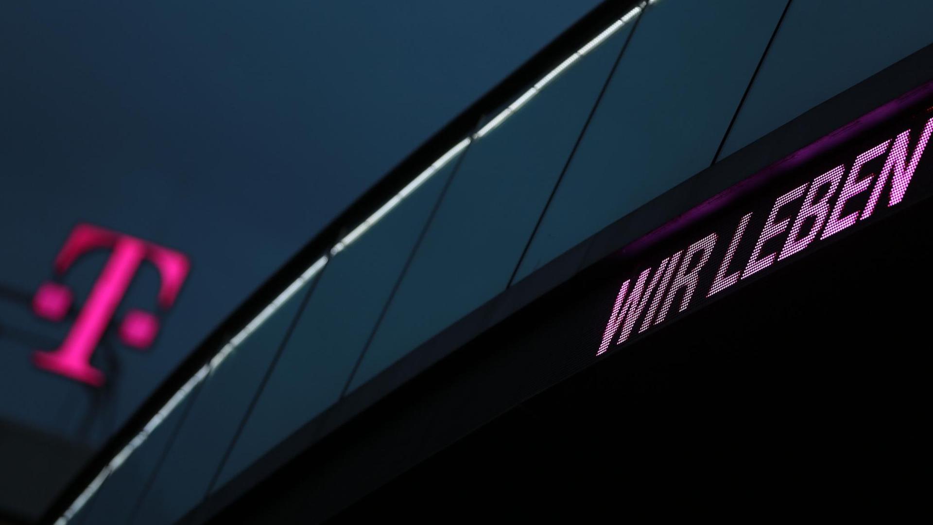 Das T-Logo der Deutschen Telekom vor dunklem Himmel. Dazu die Worte "Wir leben". Das T-Logo der Deutschen Telekom vor dunklem Himmel. Dazu die Worte "Wir leben".