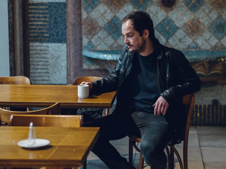 Max Czolleck, Autor von 'Desintegriert euch', sitzt im Dezember 2019 im Maxim Gorki Theater in Berlin und blickt nachdenklich auf seine Kaffeetasse.