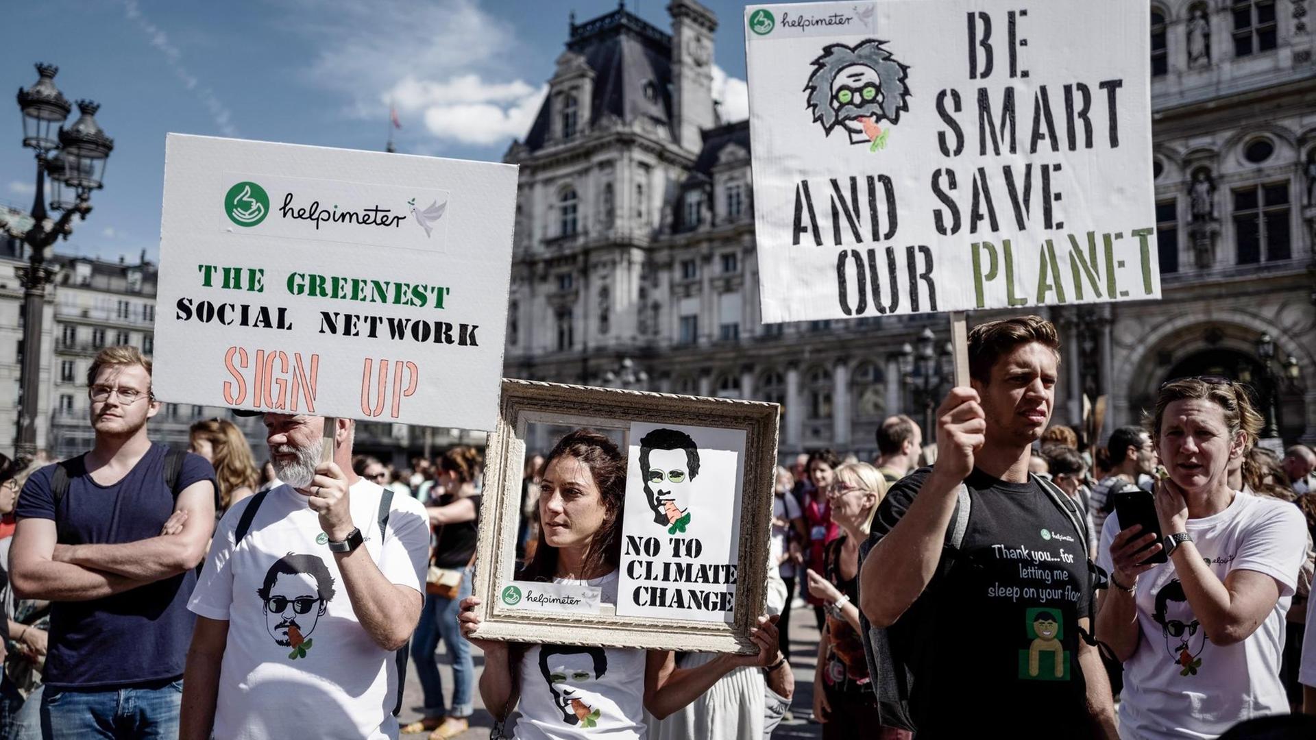In Paris demonstrieren Menschen dafür, den Klimaschutz zu verstärken. In Paris demonstrieren Menschen dafür, den Klimaschutz zu verstärken.