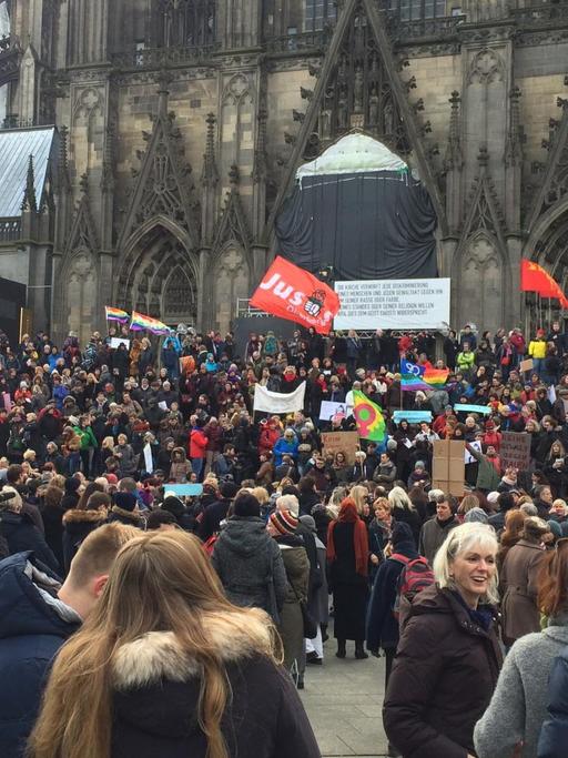 Hunderte Menschen mit Plakaten haben sich auf den Treppen des Kölner Doms versammelt.