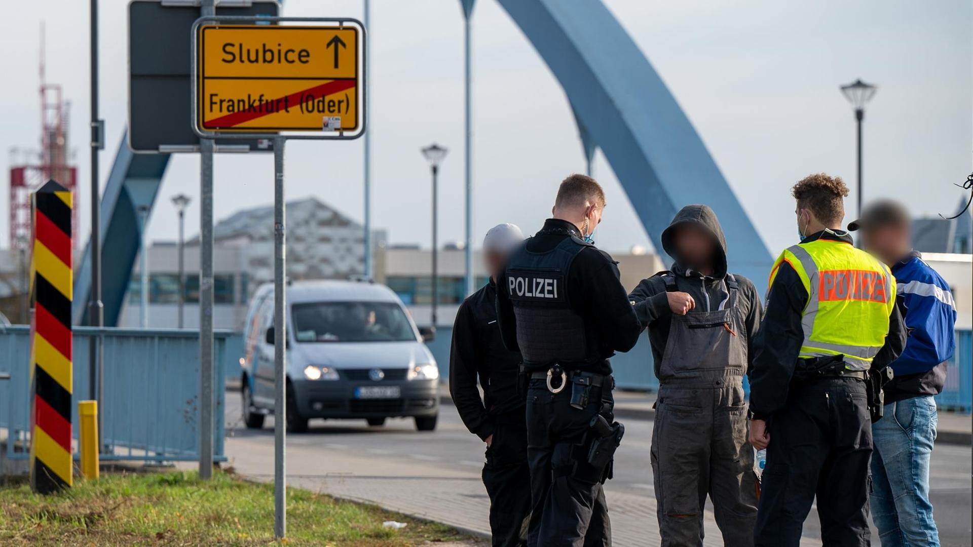 Zwei Polizisten kontrollieren auf der Grenzbrücke nach Slubice drei Männer, die die Grenze zu Fuß überquerten. Zwei Polizisten kontrollieren auf der Grenzbrücke nach Slubice drei Männer, die die Grenze zu Fuß überquerten.