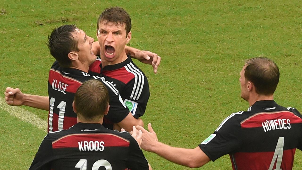Miroslav Klose fällt Thomas Müller um den Hals, der siegreiche eine Faust macht; Toni Kroos und Benedikt Höwedes laufen auf die beiden zu.