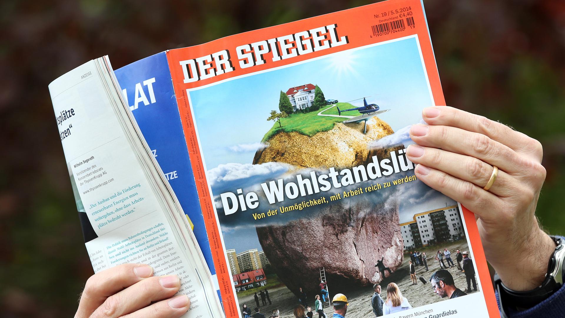 Ein Mann mit einer Ausgabe des Magazins "Der Spiegel" vom 4. Mai 2014