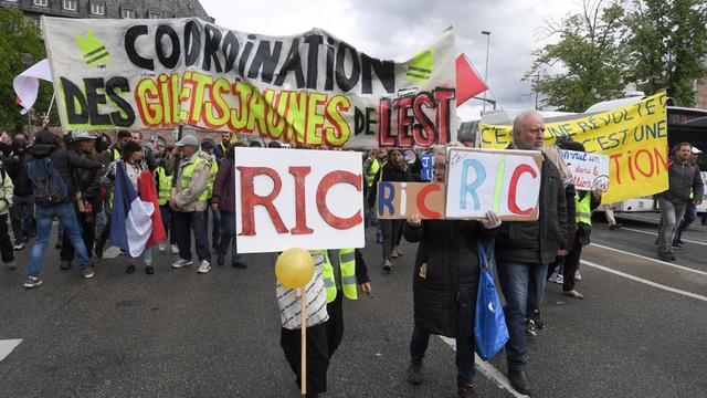 Demonstranten marschieren mit Plakaten mit der Aufschrift "RIC" (Citizens Initiated Referendum), während einer regierungsfeindlichen Demonstration der Bewegung "Gelbe Weste"