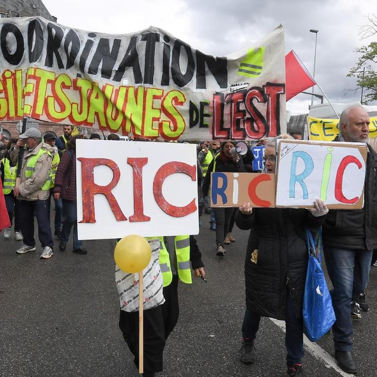 Demonstranten marschieren mit Plakaten mit der Aufschrift "RIC" (Citizens Initiated Referendum), während einer regierungsfeindlichen Demonstration der Bewegung "Gelbe Weste"