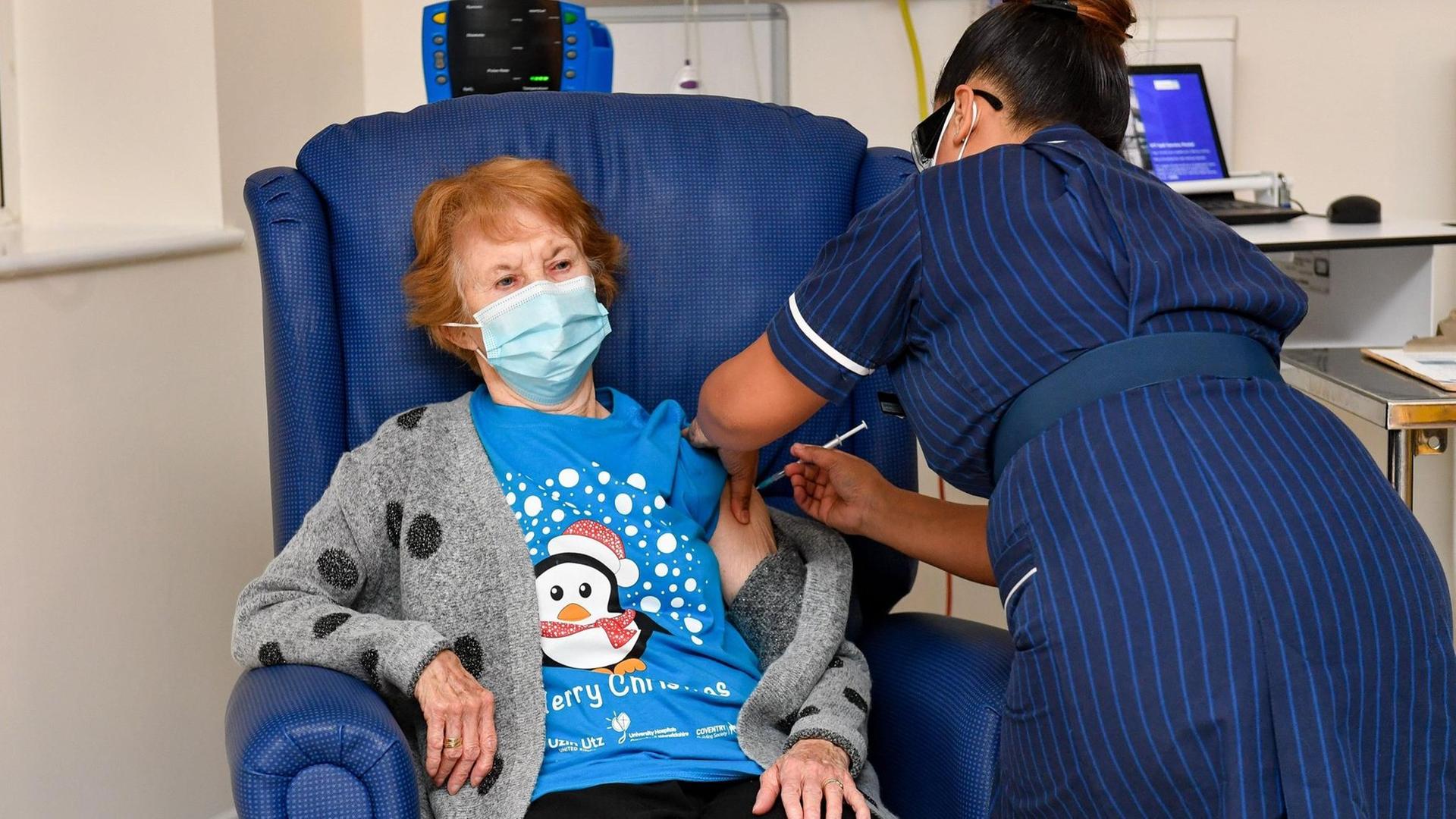 Coventry: Die 90-jährige Margaret Keenan (l) bekommt im Universitätskrankenhaus Coventry von der Krankenschwester May Parsons den Pfizer/BioNtech-Impfstoff gegen das neuartige Coronavirus. Coventry: Die 90-jährige Margaret Keenan (l) bekommt im Universitätskrankenhaus Coventry von der Krankenschwester May Parsons den Pfizer/BioNtech-Impfstoff gegen das neuartige Coronavirus.