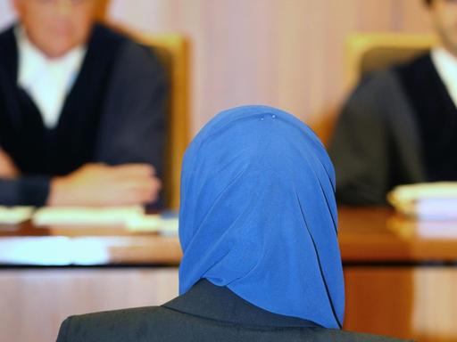 Aquila S. sitzt am 30.06.2016 im Verwaltungsgericht in Augsburg (Bayern) vor Richter Bernhard Röthinger (l). Die Jurastudentin klagt vor dem Gericht gegen Einschränkungen beim Rechtsreferendariat wegen des Tragens eines Kopftuches.