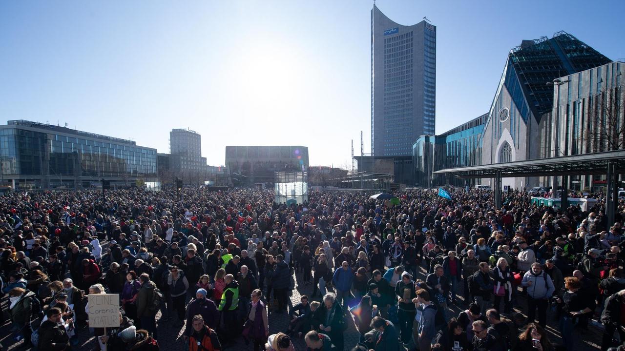 Teilnehmer einer Demonstration der Initiative "Querdenken" stehen auf dem Augustusplatz in Leipzig.