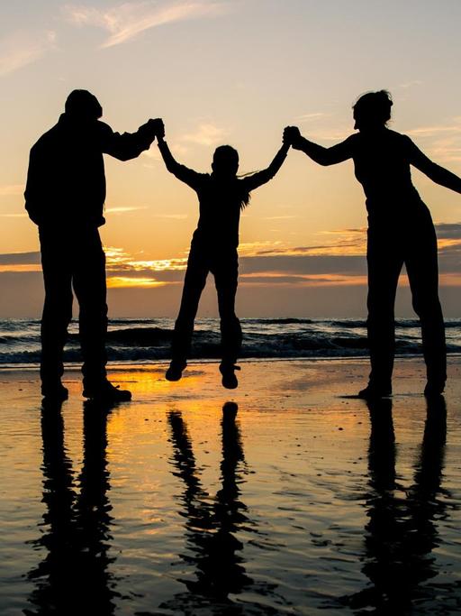 Eine Familie im Sonnenuntergang am Meer
