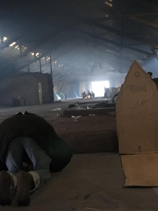 Junger Muslim betet in einer illegalen Flüchtlingsunterkunft in Belgrad