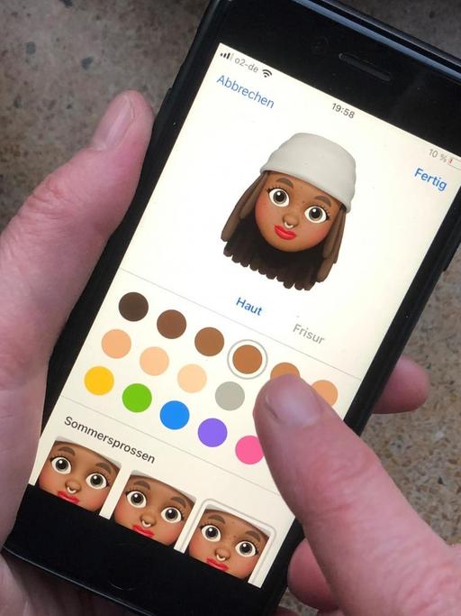 Eine weiße Person verwendet ein Emoji mit dunkler Hautfarbe