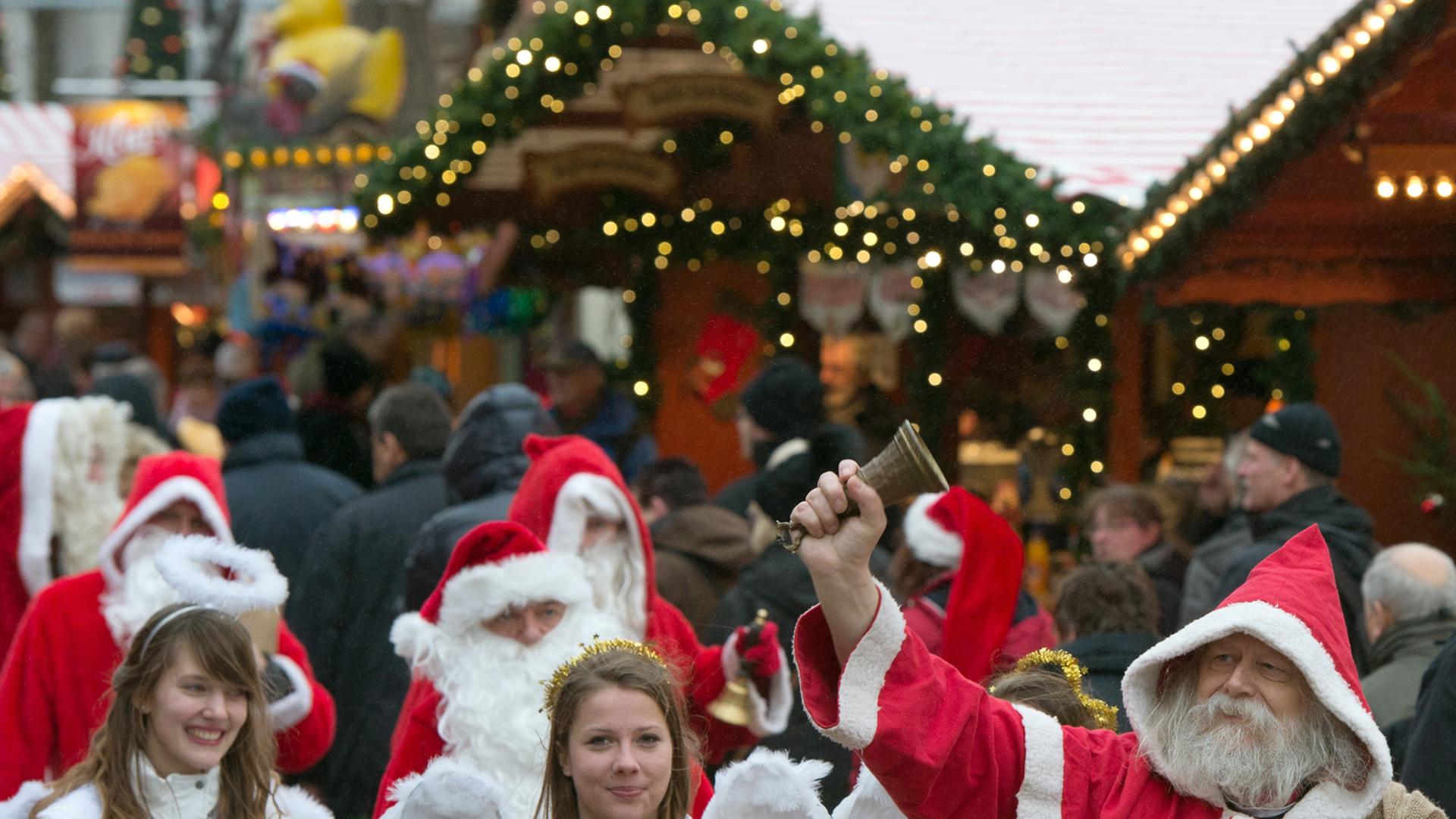 Zu sehen sind Weihnachtsmänner und Engel auf dem Weihnachtsmarkt an der Gedächtniskirche in Berlin