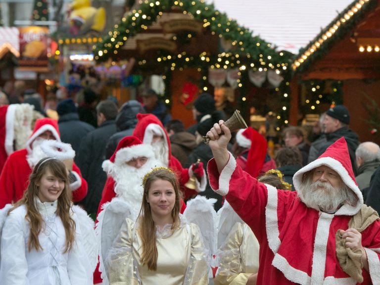 Zu sehen sind Weihnachtsmänner und Engel auf dem Weihnachtsmarkt an der Gedächtniskirche in Berlin