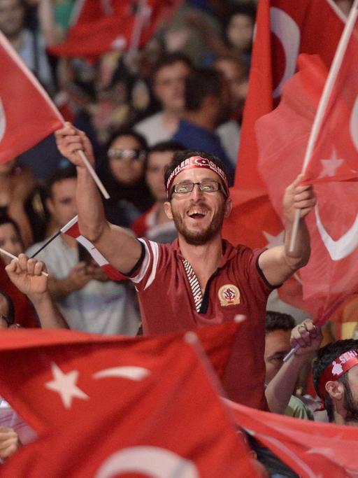 Sie sehen Anhänger von Präsident Erdogan, sie schwenken Fahnen.
