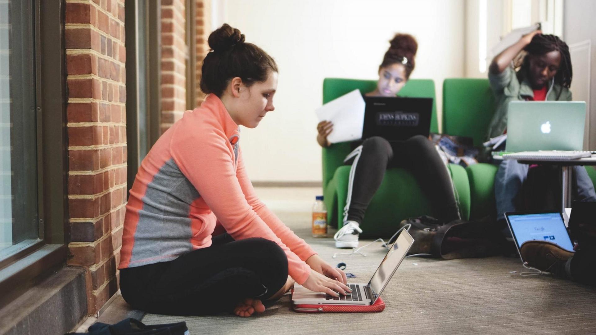 Studenten sitzen mit ihren Laptops auf Sesseln und auf dem Boden auf dem Campus ofder Johns Hopkins University in Baltimore im US-Staat Maryland, aufgenommen 2015 Studenten sitzen mit ihren Laptops auf Sesseln und auf dem Boden auf dem Campus ofder Johns Hopkins University in Baltimore im US-Staat Maryland, aufgenommen 2015