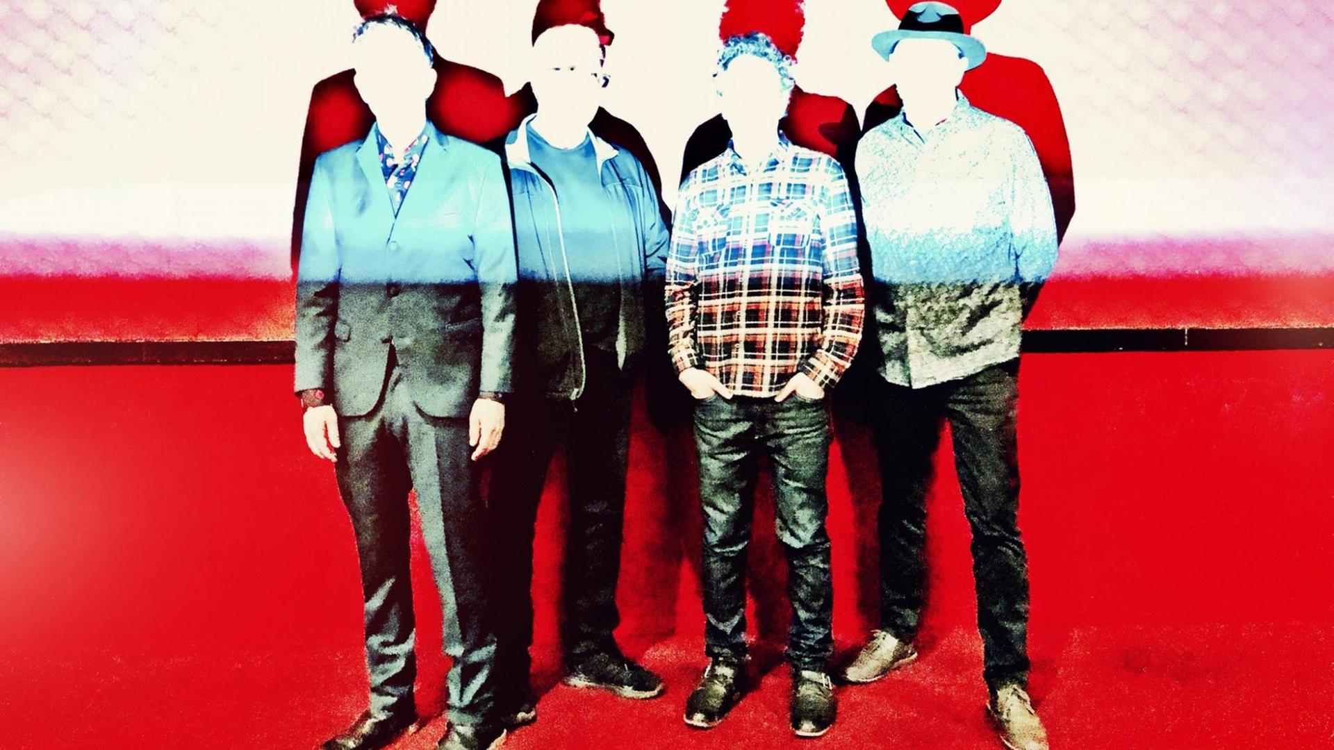 Vier Männer einer Band posieren, ihre Gesichter sind durch weißes Licht absichtlich unkenntlich Vier Männer einer Band posieren, ihre Gesichter sind durch weißes Licht absichtlich unkenntlich