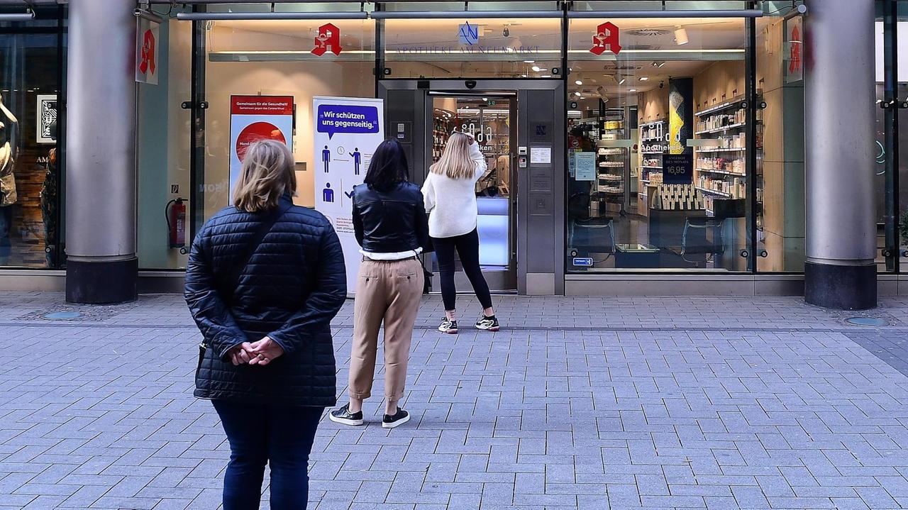 Kunden müssen am 02.04.2020 vor einer Apotheke in Köln Schlange stehen.