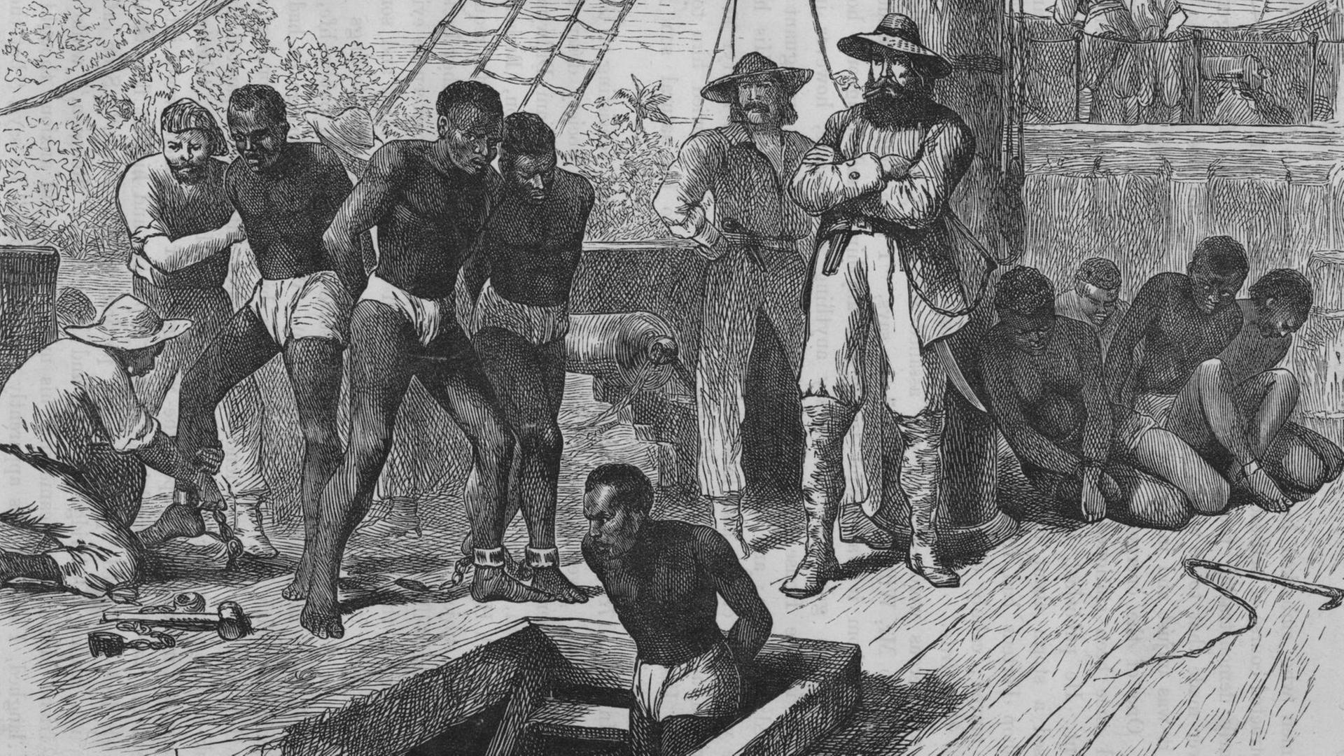 Eine historische Illustration um 1835 zeigt Sklaven an Bord eines Sklavenschiffes, die gefesselt werden, bevor sie in den Laderaum gebracht werden. Eine historische Illustration um 1835 zeigt Sklaven an Bord eines Sklavenschiffes, die gefesselt werden, bevor sie in den Laderaum gebracht werden.