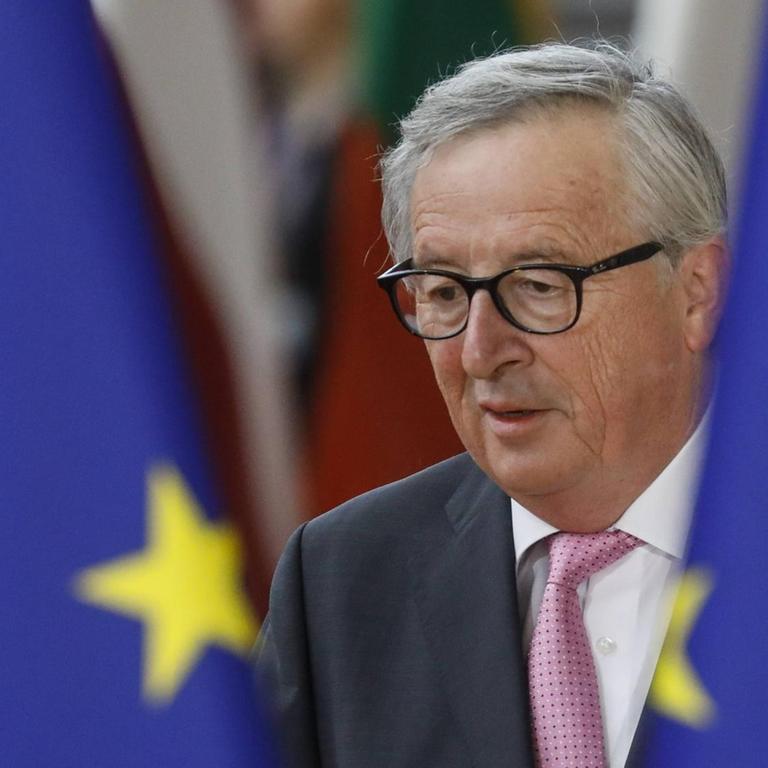 Der scheidende EU-Kommissionspräsident Jean-Claude Juncker erscheint zwischen zwei EU-Flaggen in Brüssel