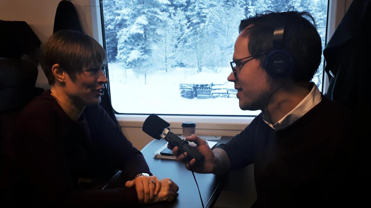 Präsidentin Kersti Kaljulaid im Interview mit Benedikt Schulz im Zugabteil. Draußen liegt Schnee. Präsidentin Kersti Kaljulaid im Interview mit Benedikt Schulz im Zugabteil. Draußen liegt Schnee.