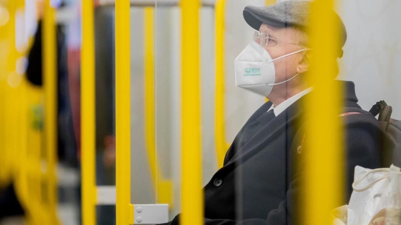 Ein Mann sitzt mit FFP2-Maske in einer U-Bahn in Berlin. Ein Mann sitzt mit FFP2-Maske in einer U-Bahn in Berlin.