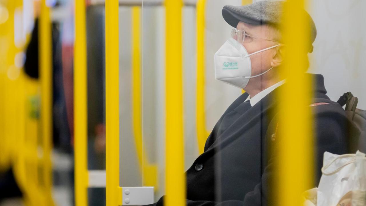 Ein Mann sitzt mit FFP2-Maske in einer U-Bahn in Berlin. Ein Mann sitzt mit FFP2-Maske in einer U-Bahn in Berlin.