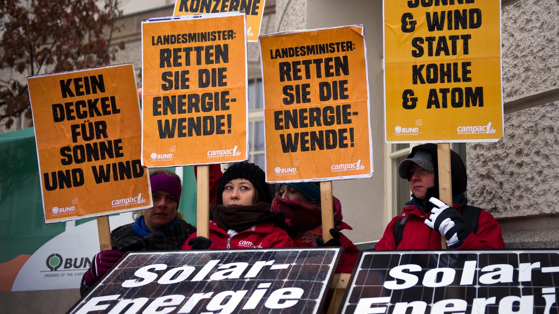 Menschen demonstrieren mit orangenen Plaktaten gegen die Ökostrom-Reformpläne von Sigmar Gabriel. Menschen demonstrieren mit orangenen Plaktaten gegen die Ökostrom-Reformpläne von Sigmar Gabriel.