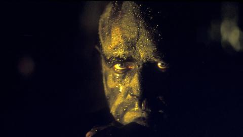 Ausschnit aus "Apocalypse Now" mit Marlon Brando in der Nahaufnahme, der ein geschmiktes Gesicht hat in seiner Rolle als Colonel Kurtz