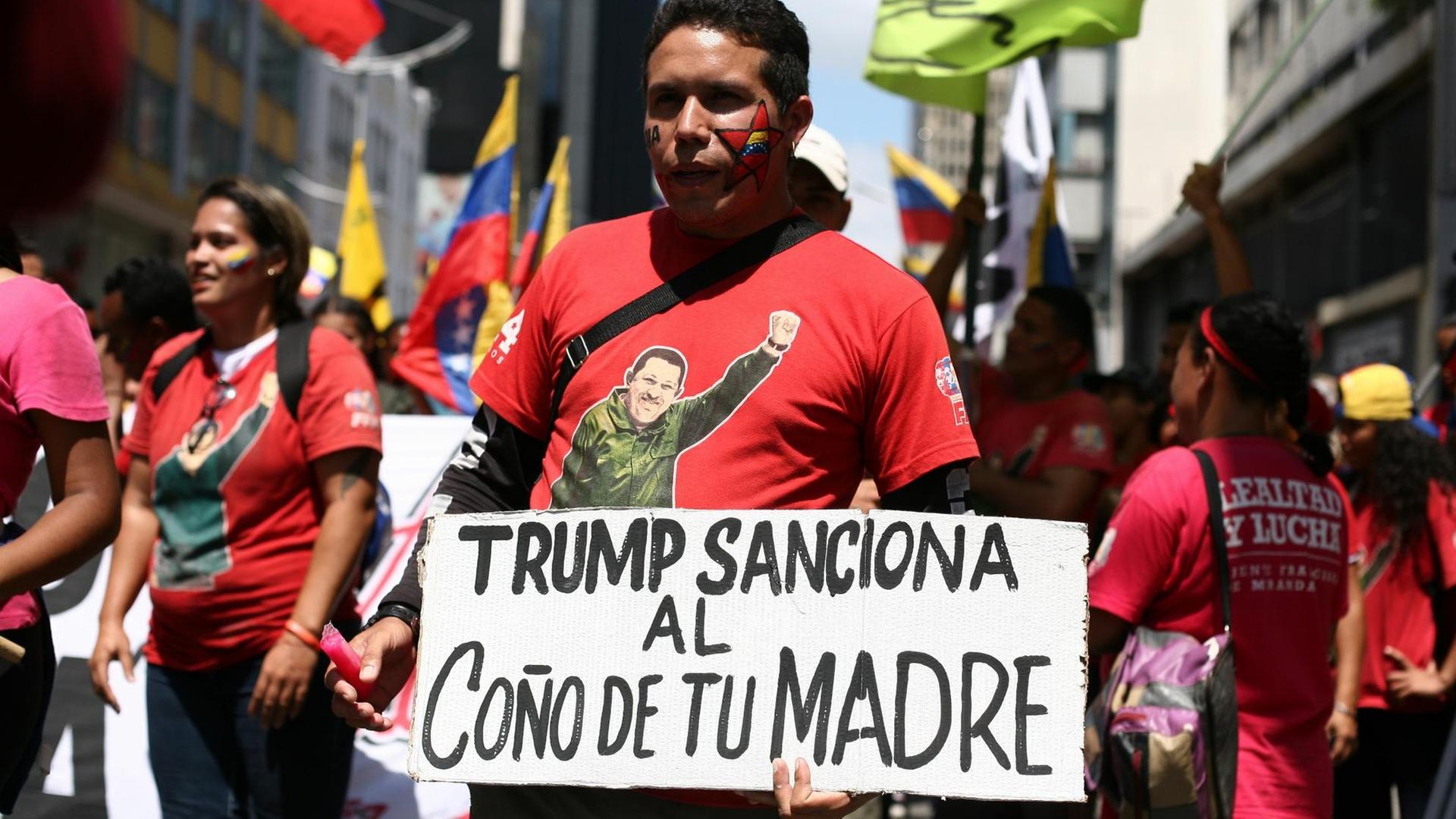 Ein Demonstrant mit einem Plakat bei einer Kundgebung gegen die neuen US-Sanktionen