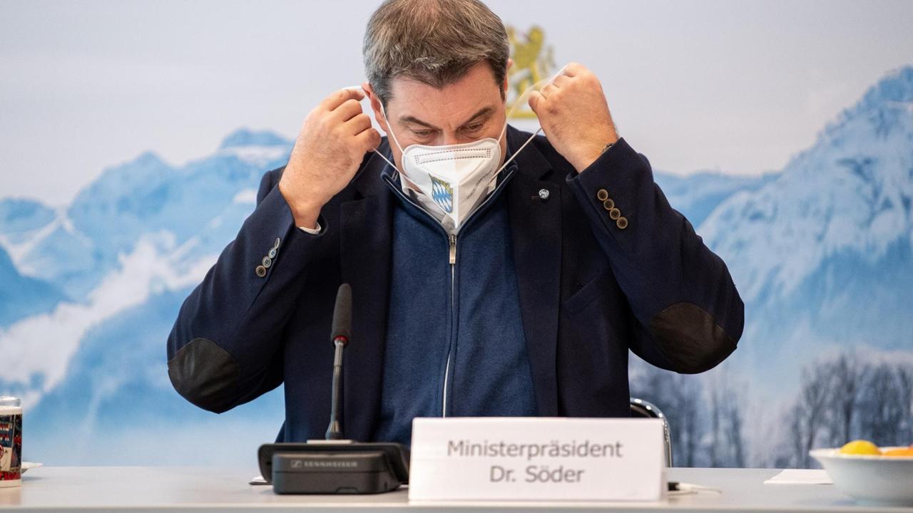 Markus Söder (CSU), Parteivorsitzender und Ministerpräsident von Bayern, nimmt zu Beginn einer Sitzung des Ministerrats in der Staatskanzlei seine FFP2-Schutzmaske ab. Markus Söder (CSU), Parteivorsitzender und Ministerpräsident von Bayern, nimmt zu Beginn einer Sitzung des Ministerrats in der Staatskanzlei seine FFP2-Schutzmaske ab.